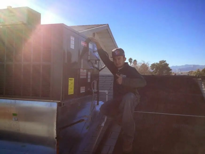 HVAC technician performing AC Tune-Up on a rooftop unit in Cody